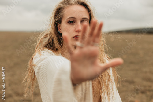 Woman showing stop gesture in field photo