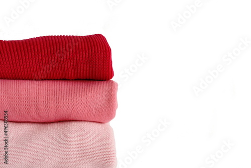 Różowe swetry ułożone w stos. Zdjęcia na białym tle z wolną przestrzenią. © ArtTum