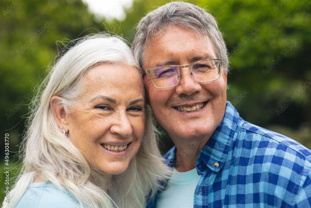 Portrait of happy caucasian senior couple spending leisure time together in backyard