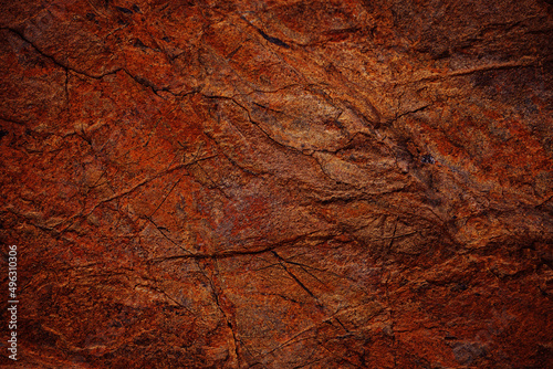 Red brown rock texture. Cracked mountain surface. Close-up. Stone background with space for design. Rusty grunge backdrop.