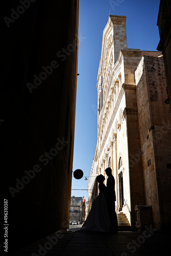 sposi in silhouette e sullo sfondo la cattedrale di Cagliari (Sardegna -Italia) photo