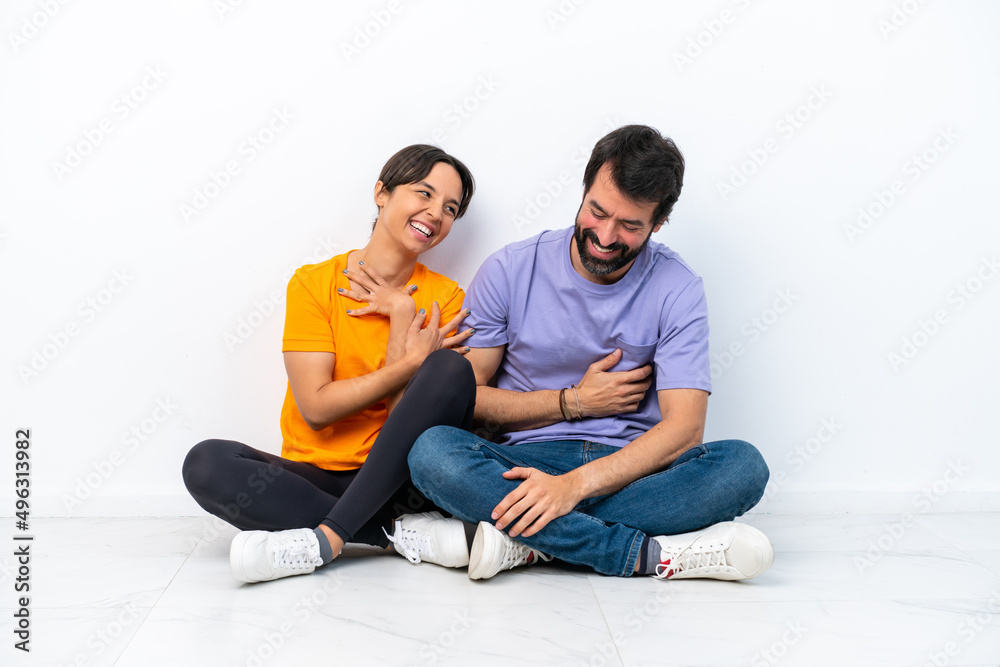 Young caucasian couple sitting on the floor isolated on white background smiling a lot Young caucasian couple sitting on the floor isolated on white background smiling a lot