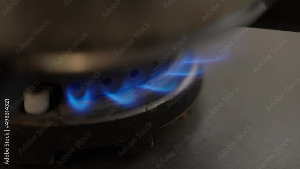 Closeup of gas fire under pot in kitchen. Blue gas flames burning. Gas heating Closeup of gas fire under pot in kitchen. Blue gas flames burning. Gas heating
