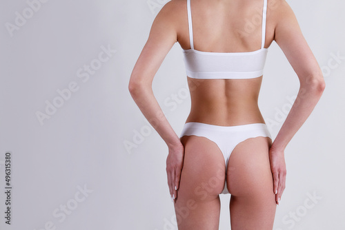 Close up shot of unrecognizable fit woman in lingerie isolated on white background. Cropped shot of lower half of slim attractive female's body in white underwear. Copy space for text.