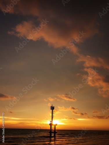 silhouette of a small lighthouse on a sunset