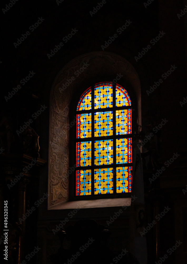 Stained glass window in the church. Light passing through stained glass. Bright stained glass window. Interiors of an old church with stained glass windows