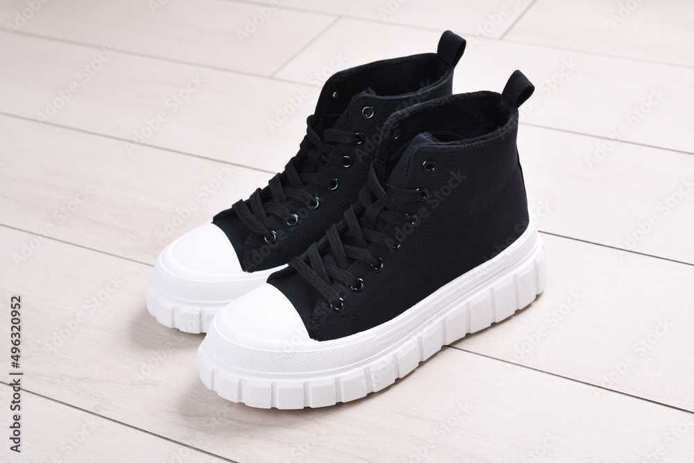 A pair of black sneakers with white soles. A pair of black sneakers with white soles.