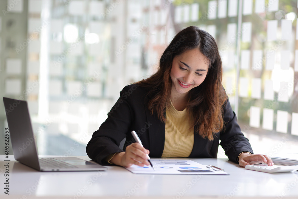 Business woman in the office working with financial data using calculator and writing make notepad. Business financial and accounting concept. Business woman in the office working with financial data using calculator and writing make notepad. Business financial and accounting concept.