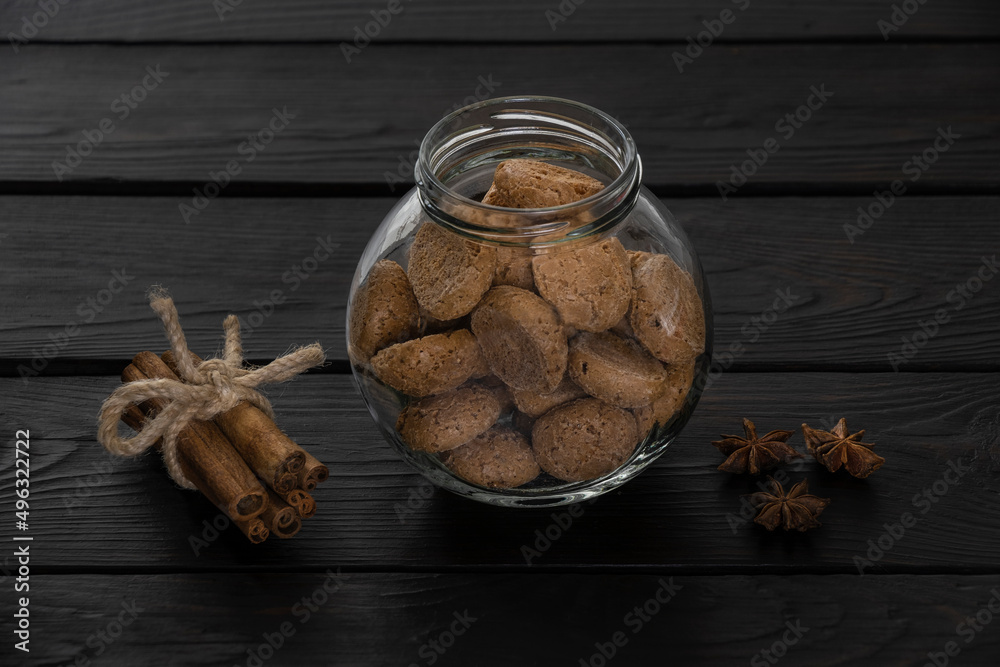 Jar of cookies for coffee and aromatic spices on dark backgorund