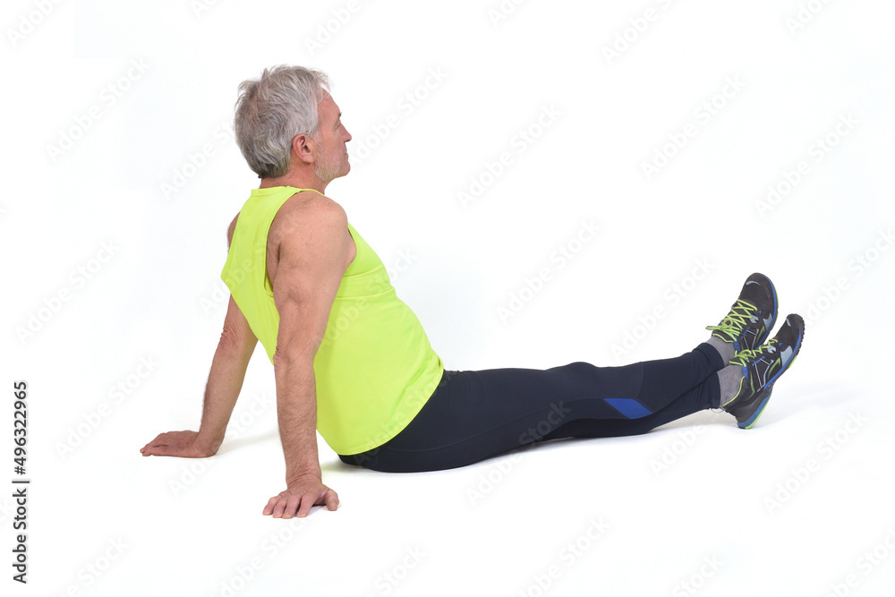 Obraz premium relaxed senior man with sportswear sitting on the floor on white background