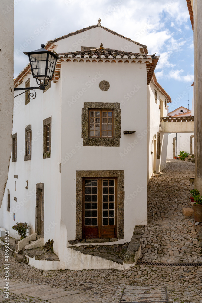 vertical view of a cobblestone street and historic whitewashed houses in the old city center of Marvao