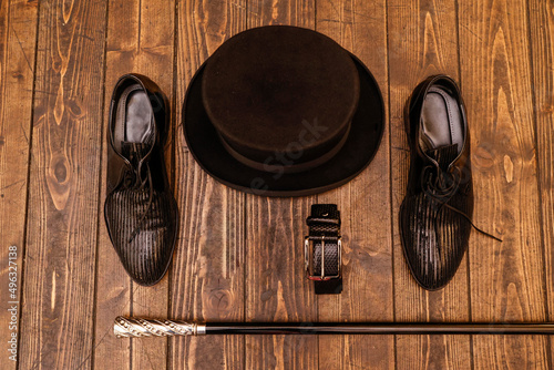 dettaglio di cappello , bastone scarpe e  cinta eleganti su tavolo in legno  photo
