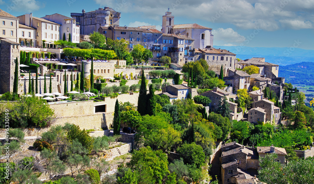 Scenic panoramic view on medieval picturesque old french village on hill top, blue summer sky, fluffy clouds - Gordes, Provence, France