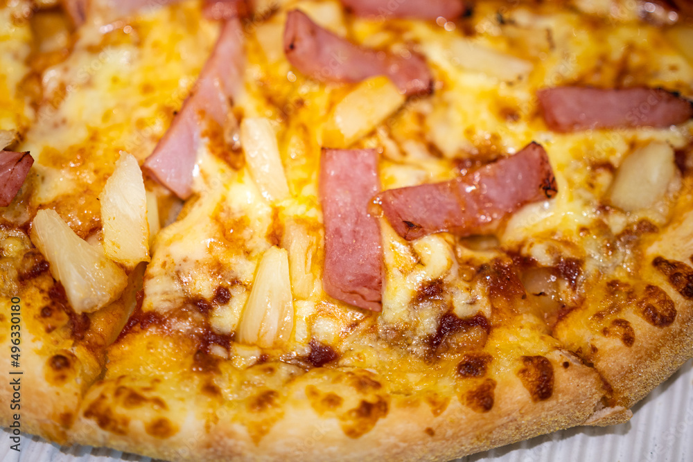 Hawaiian pizza with sliced ham and pineapple topping. Italian food top view close-up photo. Hawaiian pizza with sliced ham and pineapple topping. Italian food top view close-up photo.