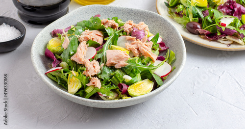 Tuna salad with lettuce, spring onions, brussels sprout, cabbage, arugula, radish and canned tuna. Vitamin salad. Close up.