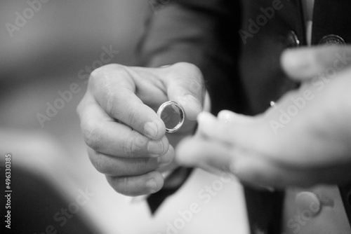 foto in bianco e nero dello scambio delle fedi tra due sposi 