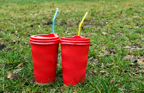 two red coffe cups on the green grass with bkue and yellow tube  for cocktail as ukrainain flag photo