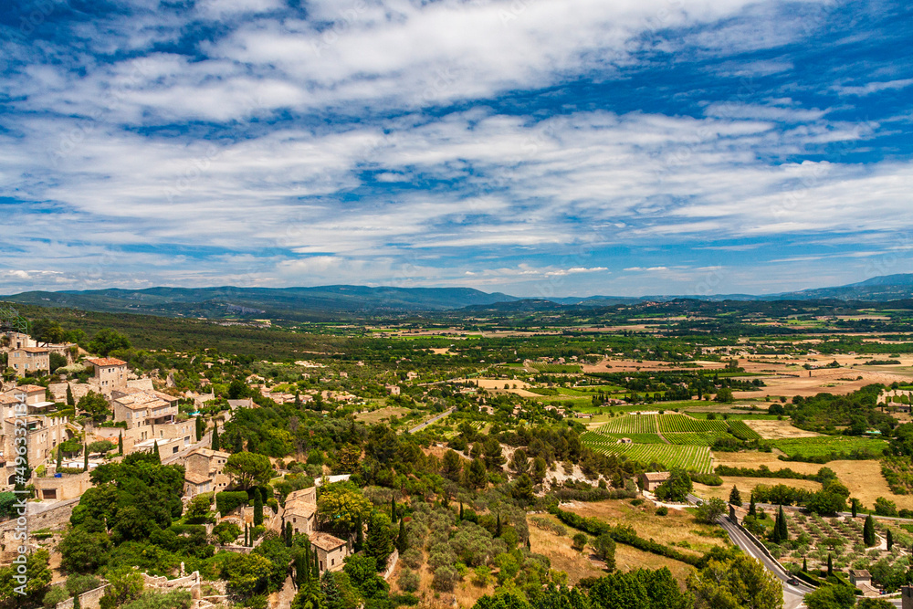 A small village with green fields under a cloudy sky in a sunny day in Avignon, Provence, France