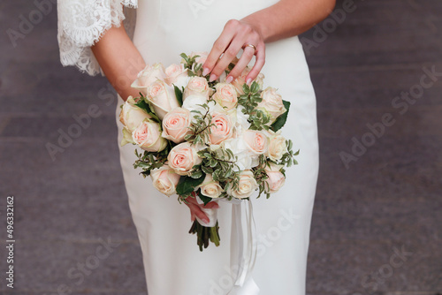 bellissimo dettaglio del bouquet di fiori di colori tenui  tenuto in mano da una sposa  photo