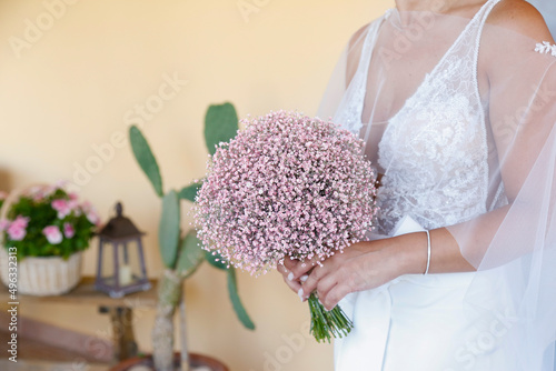 bellissimo mazzolino di fiori freschi colorati tenuto in mano da una neo sposa photo