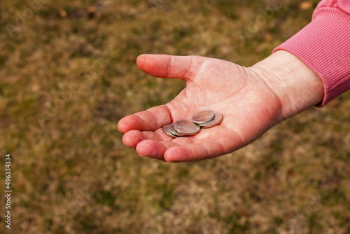 Last money for groceries. Coins in the hand of a middle-aged woman. The concept of the world food crisis associated with the war in Ukraine © Nataliia