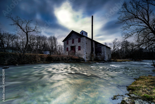 The old Babcock Mill and Cascade in Odessa Ontario Canada featuring long exposure and moving water with stunning cloud features and old buildings.  