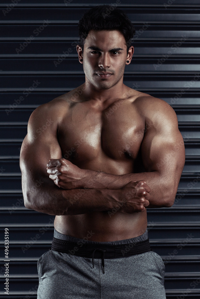 Fototapeta premium Look at this hunk of a man. Cropped portrait of an athletic young man posing against a dark background.