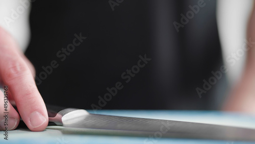 Cook put down the sharp knife on desk in kitchen close-up photo