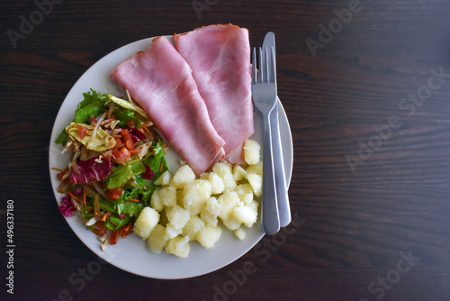 Ham, mixed vegetable salad with balsamic honey dressing and boiled potatoes on a plate. photo