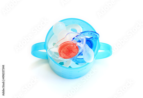 Child soothers in a blue baby cup. Red white and blue colours photo