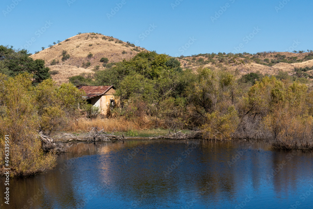 Landscape with abandoned house, lake, mountains at Ruby Ghost Town, AZ