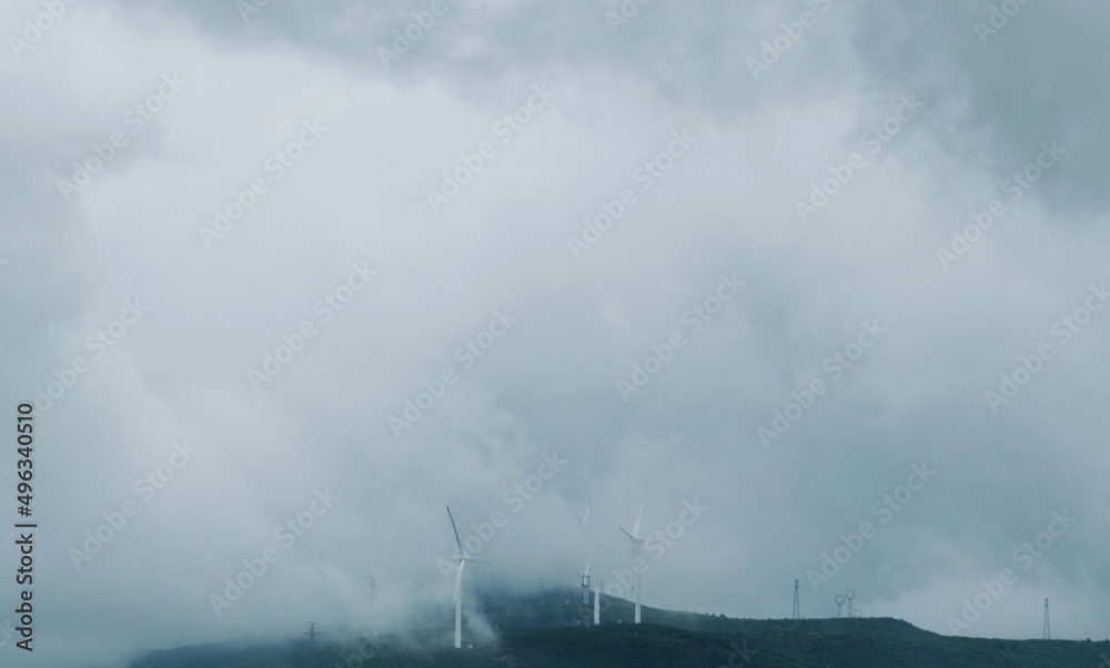 Fototapeta premium Windmills with fog on mountain