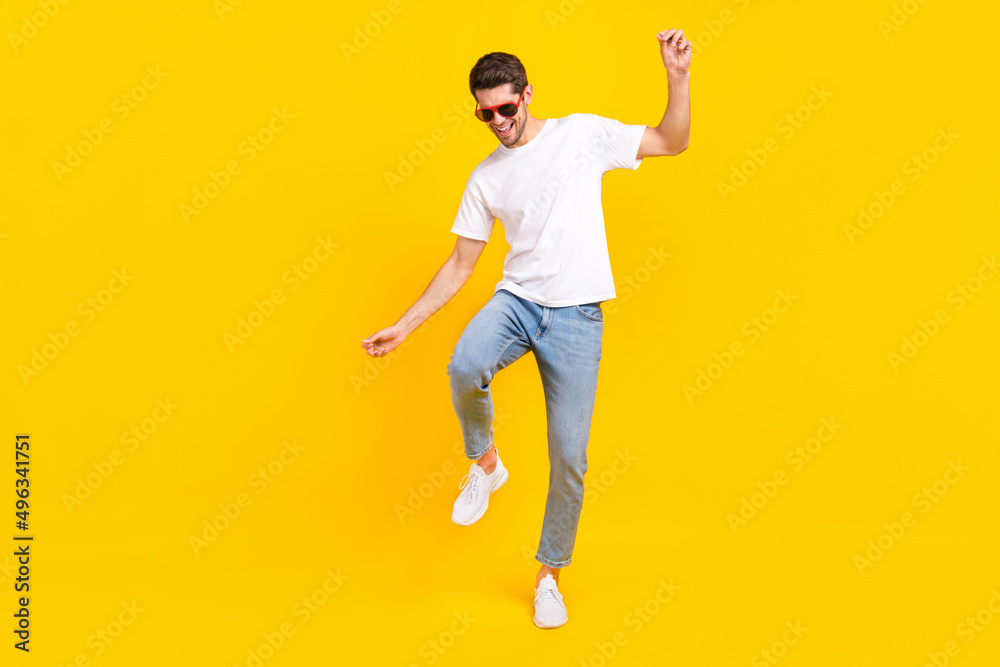 Full body photo of cool young brunet guy dance wear eyewear t-shirt jeans shoes isolated on yellow background