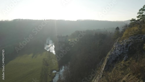 Aerial view of a woman on the rocks with Walzin castle in background at sunset, Dinant, Namur, Belgium. photo