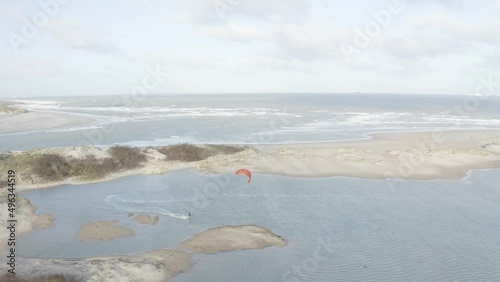 Arial view of a person doing windsurf among sand dunes in a bay in Retranchement, Netherlands. photo