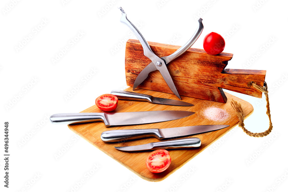 Set of various kitchen knives on wooden cutting boards. Vegetables, salt.