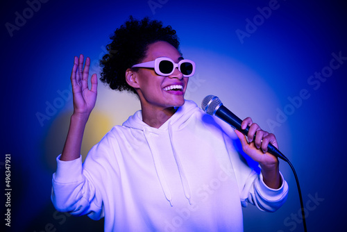 Photo of charming funky lady dressed hoodie dark eyewear singing song isolated blue color background