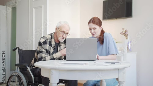 A social worker helps a wheelchair user buy medicines online