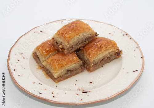 turkish dessert bakalva, five pieces of baklava on white plate and white background, isoleted, close up 