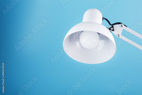 White table office lamp on blue background with space for text and idea concept