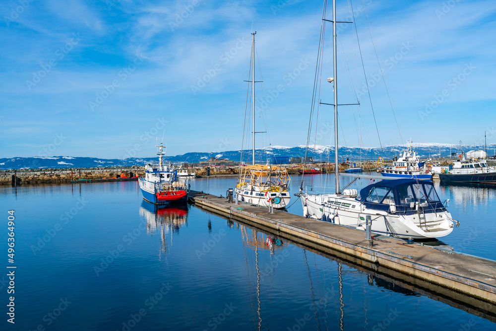 Fototapeta premium Harbour with moored sailboats and reflections in water, Trondheim, Norway