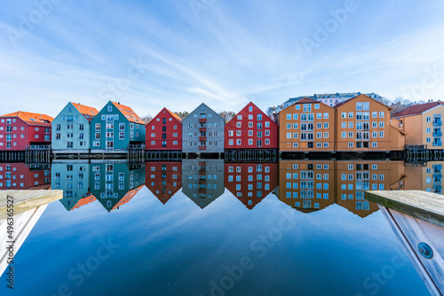 Colorful old wooden houses with reflections in the river Nidelva in the Brygge district of Trondheim, Norway