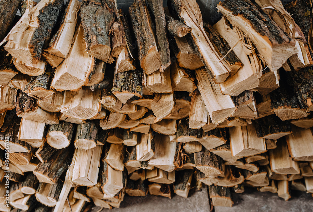 Logs chopped with an ax, dry acacia firewood, spruce for heating lie in a row close-up in the forest. Logs chopped with an ax, dry acacia firewood, spruce for heating lie in a row close-up in the forest.