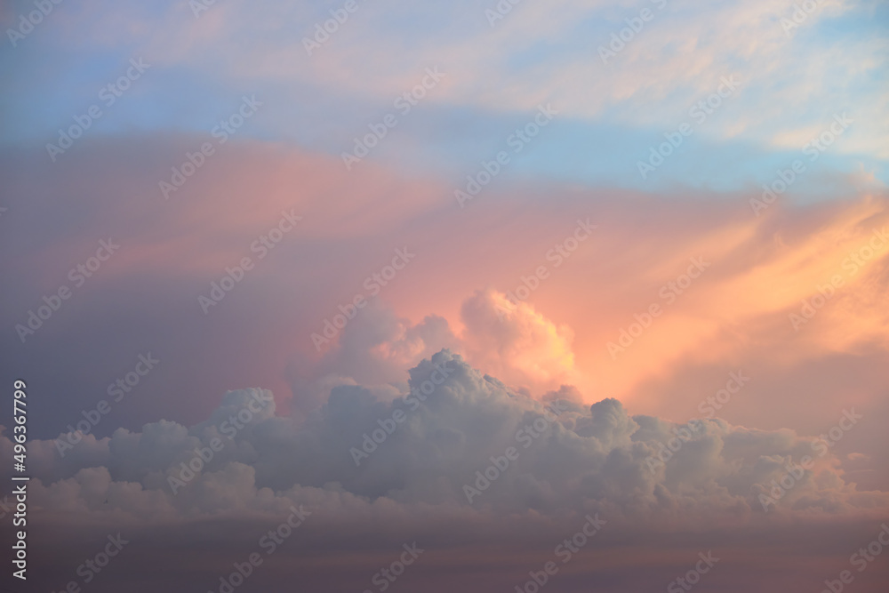Colorful evening landscape with soft pastel coloured clouds on watercolor tinted sunset sky. Abstract nature background