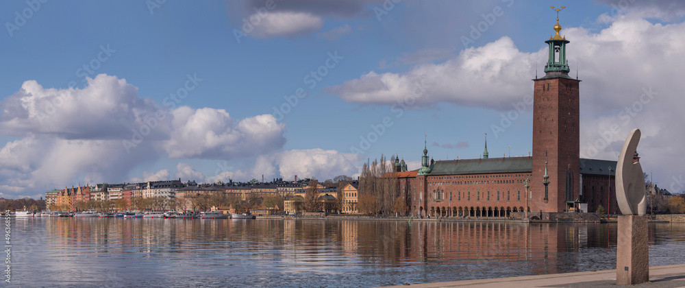 Panorama view with abstract sculpture on a parterre and the Town City Hall at the waterfront Norr Mälarstrand a sunny spring day in Stockholm