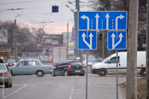 Traffic sign pointing multiple road lanes direction on city street. Signboard arrows for urban transport safety guidance