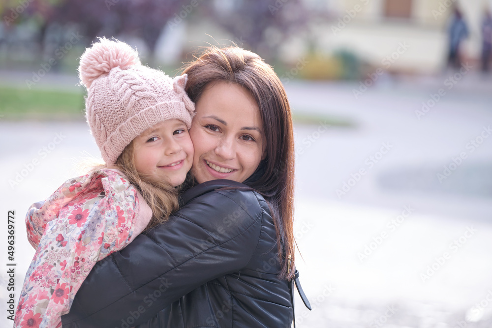Fototapeta premium Young pretty woman hugging lovingly her child daughter. Happiness in family relations concept