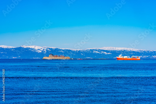 A cargo vessel approaches Munkholmen island on Trondheim fjord (Trondheimsfjorden), an inlet of the Norwegian Sea, Norway. photo