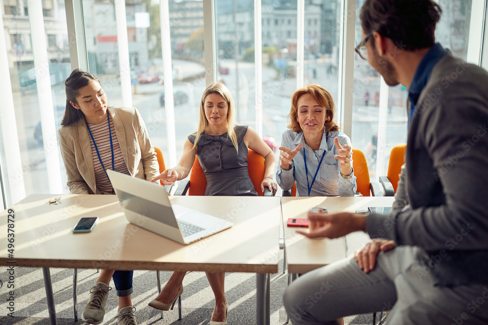 A group of young business people in commission is chatting during a break of an interview for a new job position. Business, people, company A group of young business people in commission is chatting during a break of an interview for a new job position. Business, people, company