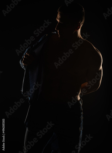 Portrait of a guy putting on his shirt, silhouette